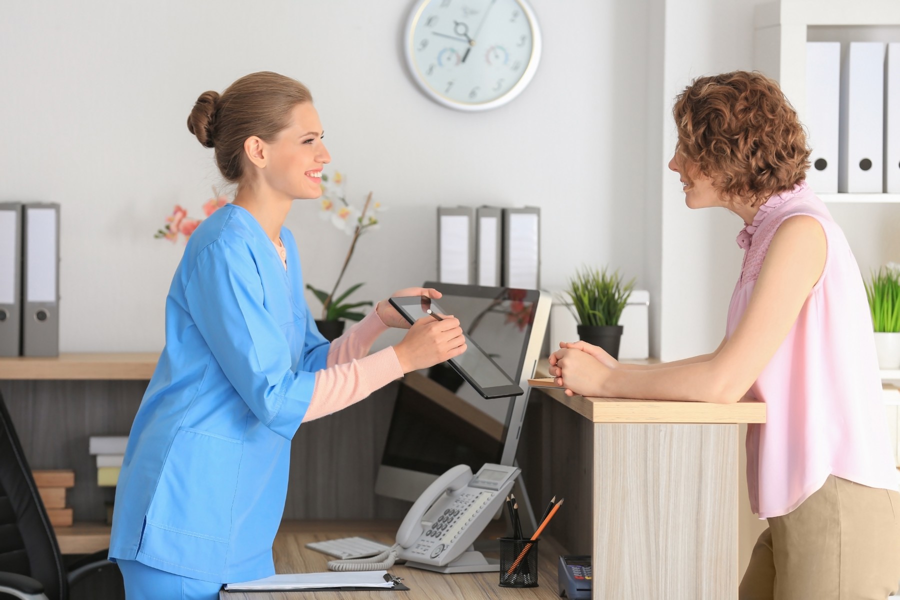 How Payment Plans Can Help Your Medical Practice   Medical Receptionist With Patient Jpg 1800x1200 